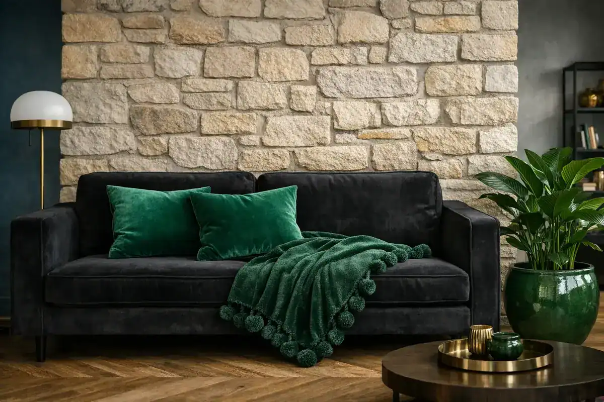 coussins velours vert émeraude et plaid à pompons vert forêt sur canapé noir objets design colorés style contemporain salon